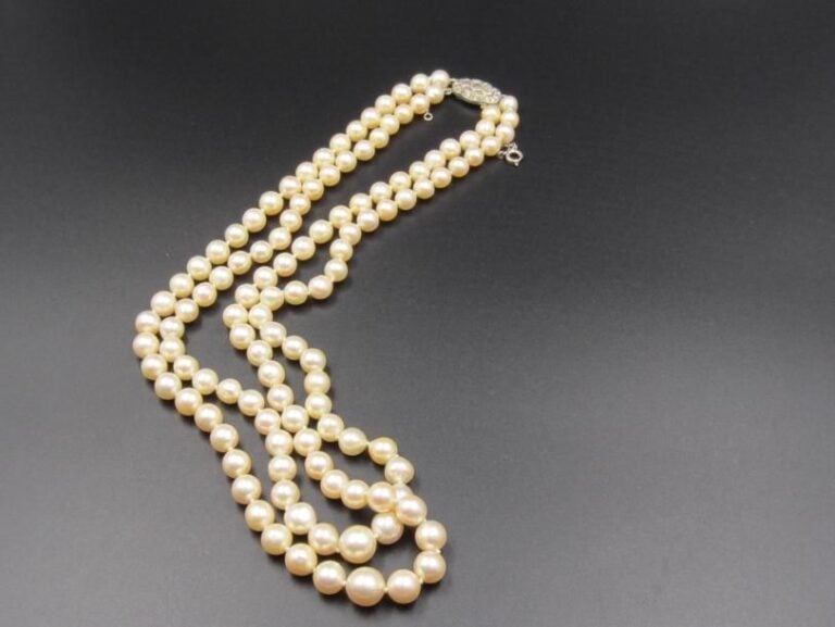 COLLIER composé de deux rangs de perles de cultures blanches, en chute, dont certaines légèrement baroque