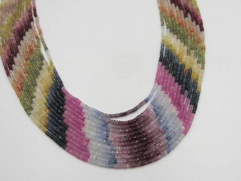COLLIER composé de douze rangs de saphirs facettés multicolores, en chute et en dégradé de couleu