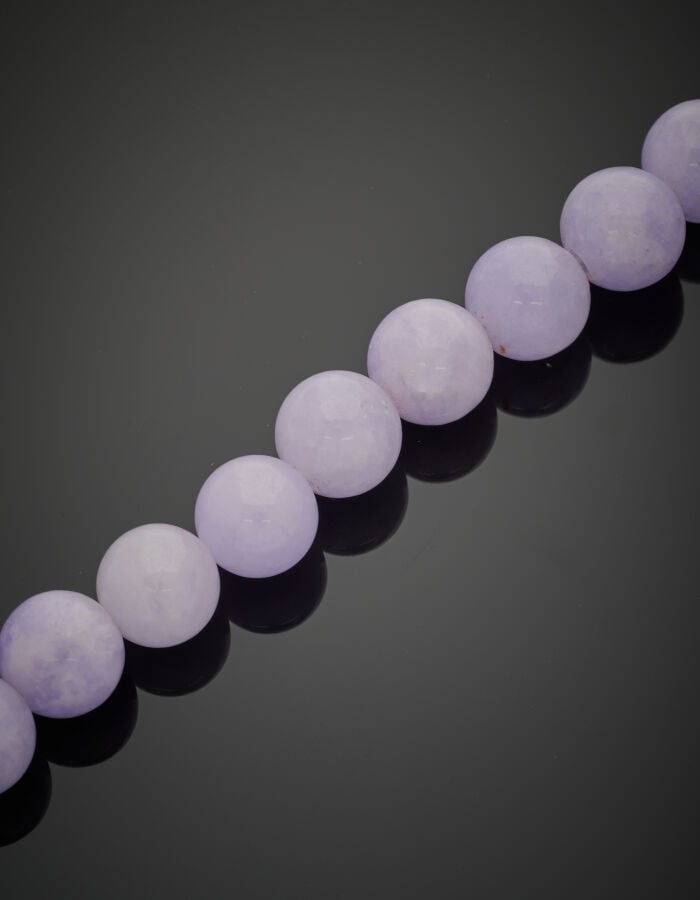 COLLIER composé de perles de jade de couleur lavande, en chute. Fermoir en or g…