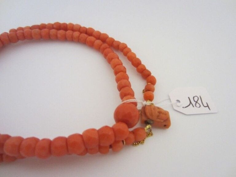 COLLIER composé de perles facettées de corail, en chut