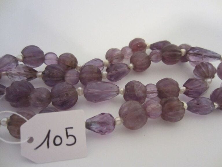 COLLIER composé de perles facettées ou godronnées d?améthystes de taille différentes alternées de perles baroques, en chut