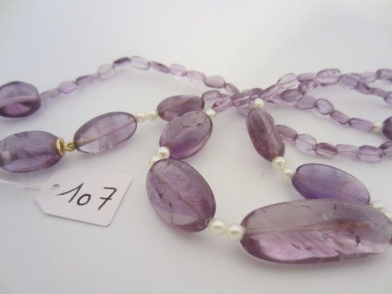 COLLIER composé de perles ovales d?améthystes de taille différentes alternées de perles baroque