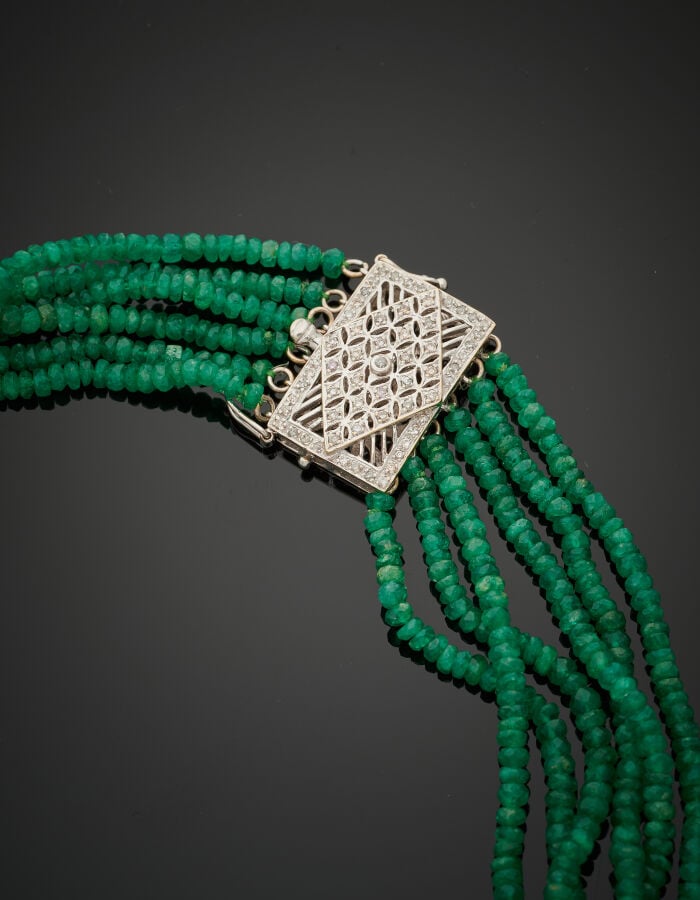 COLLIER composé de six rangs de perles d'émeraudes facettées, en chute, parsemé…