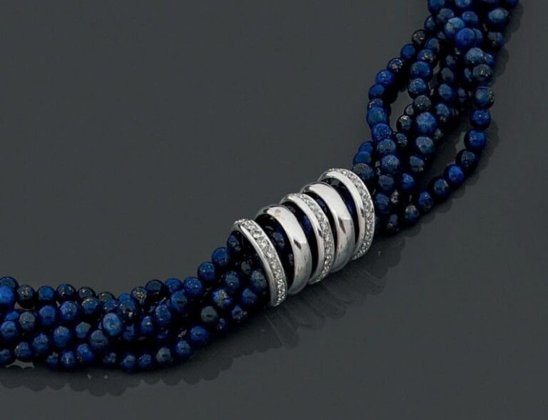 COLLIER composé de six rangs de perles de lapis lazuli retenus par cinq anneaux en or gris (750 millièmes) dont trois sertis de diamant
