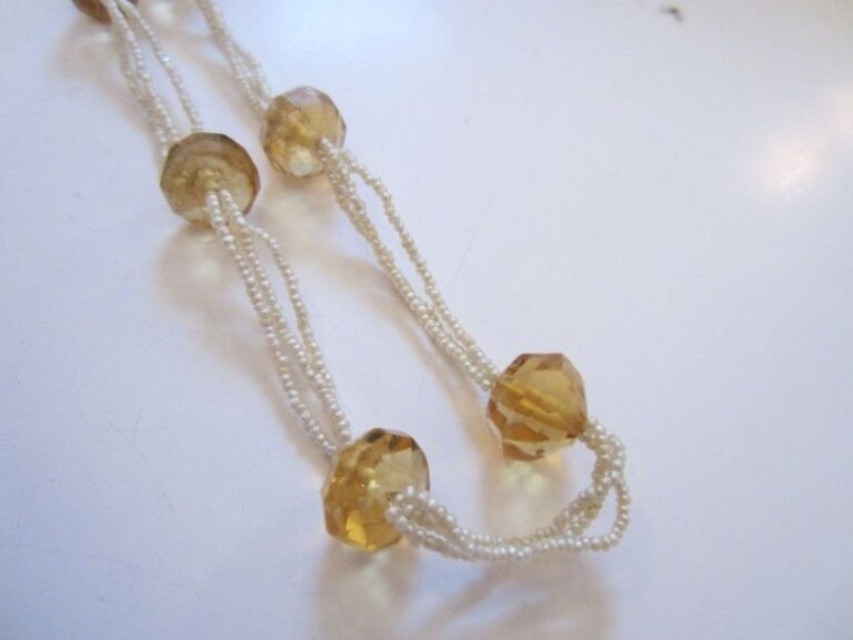 COLLIER composé de trois rangs de perles fines ponctuées de 11 perles de citrines facettées, en chut