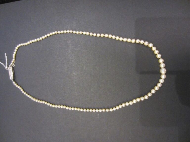 COLLIER composé d’un rang de 113 perles non testées, en chute Fermoir en or gris 14 carats (585 millièmes) serti de cinq diamants taillés en rose dont un, au centre, plus important Dans son écrin