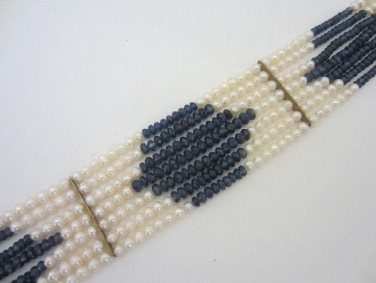 COLLIER DE CHIEN composé de sept rangs de perles de culture blanches alternées de saphirs facettés, fermoir méta