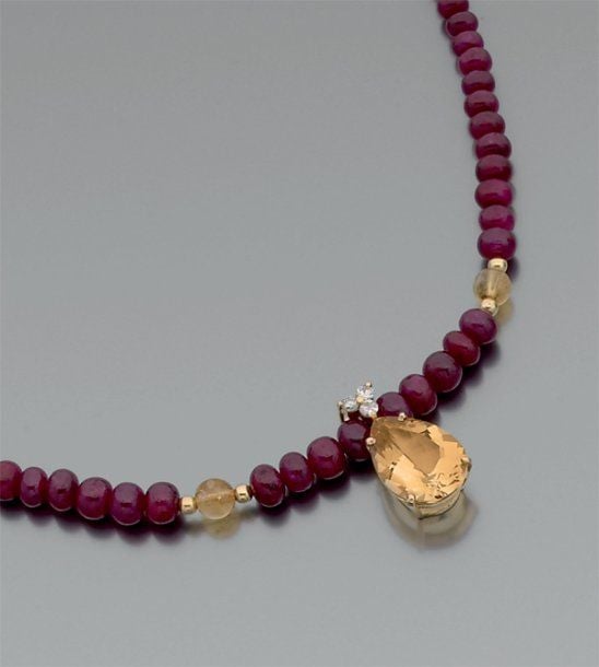 Collier de perles de rubis en chute ponctué de perles de citrine et de boules d'or jaune retenant un pendentif en or jaune serti d'une citrine de forme poire surmontée de 3 diamants de taille brillan