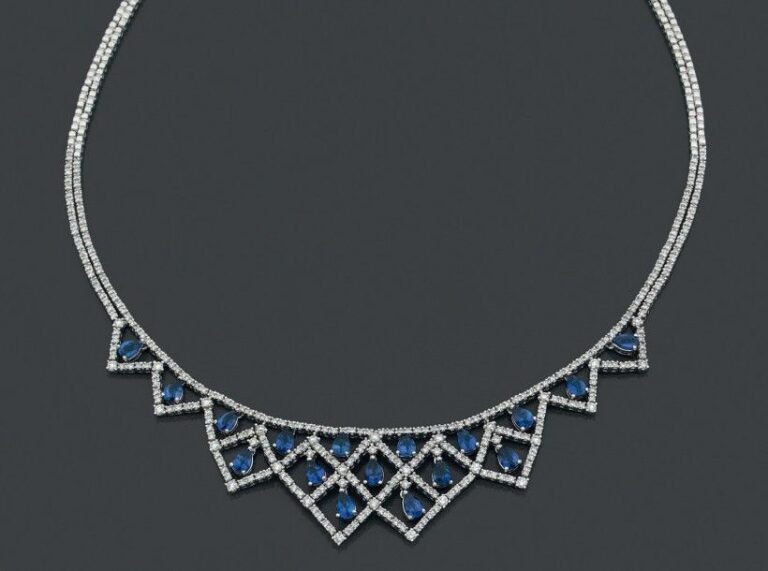 COLLIER «draperie» en or gris (750 millièmes) ajouré sertis de lignes de diamants taille brillant ponctuées de saphirs taillés en poir