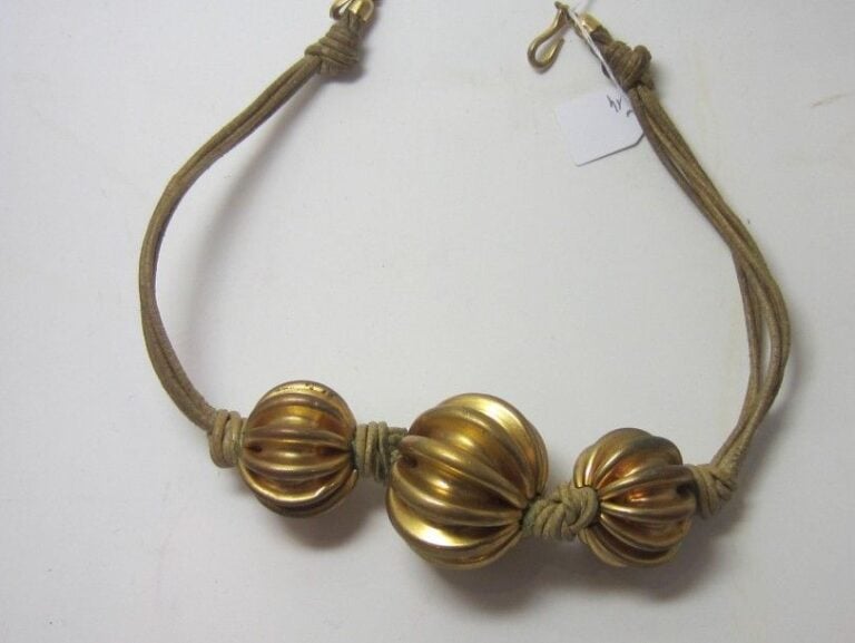 COLLIER en métal doré orné de trois importantes boules godronnée