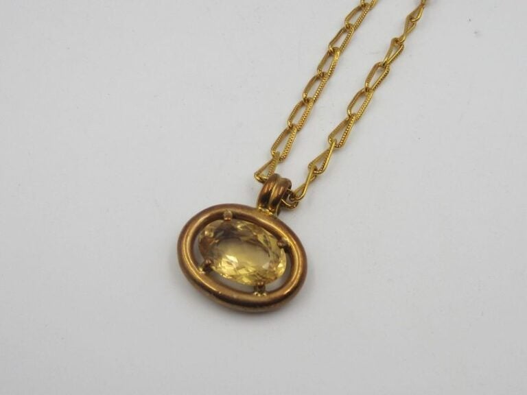 COLLIER en métal doré retenant un pendentif serti d'une citrine