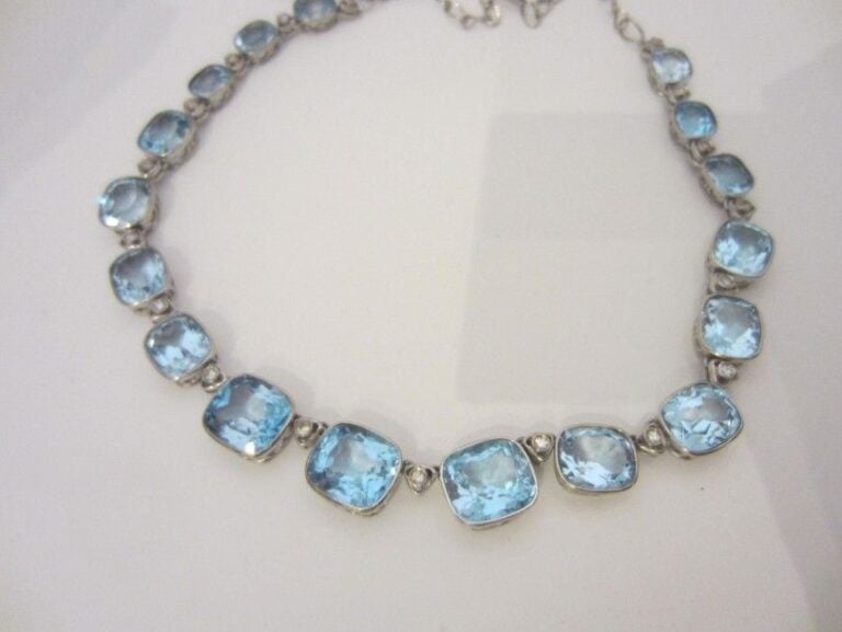 COLLIER en or gris 14 carats (585 millièmes) articulé serti de 17 topazes bleues de forme coussin en chute, alternées de diamants 8 8