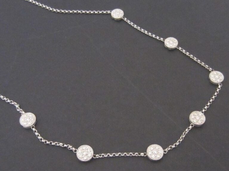 COLLIER en or gris 14 carats (585 millièmes) composé d'une chaînette retenant sept pastilles pavées de diamants taille brillan