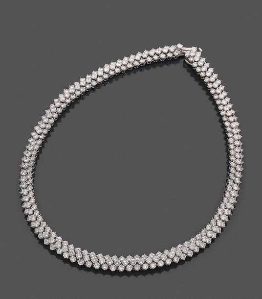 •COLLIER en or gris (750‰) articulé, serti de trois alignements de diamants taille brillan