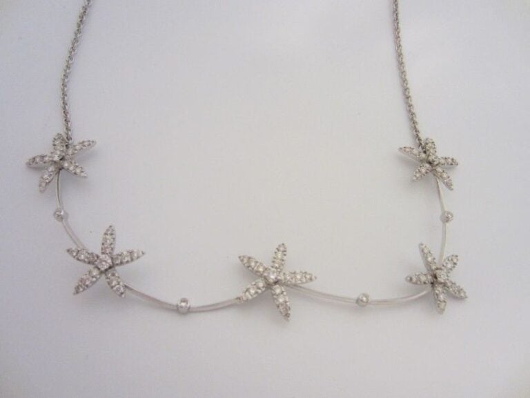 COLLIER en or gris (750 millièmes) composé de cinq motifs étoilés serti de diamants taille brillan