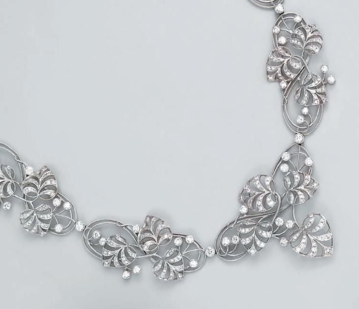 COLLIER en or gris ajouré serti de diamants taille brillant, à motifs de feuilles et volute