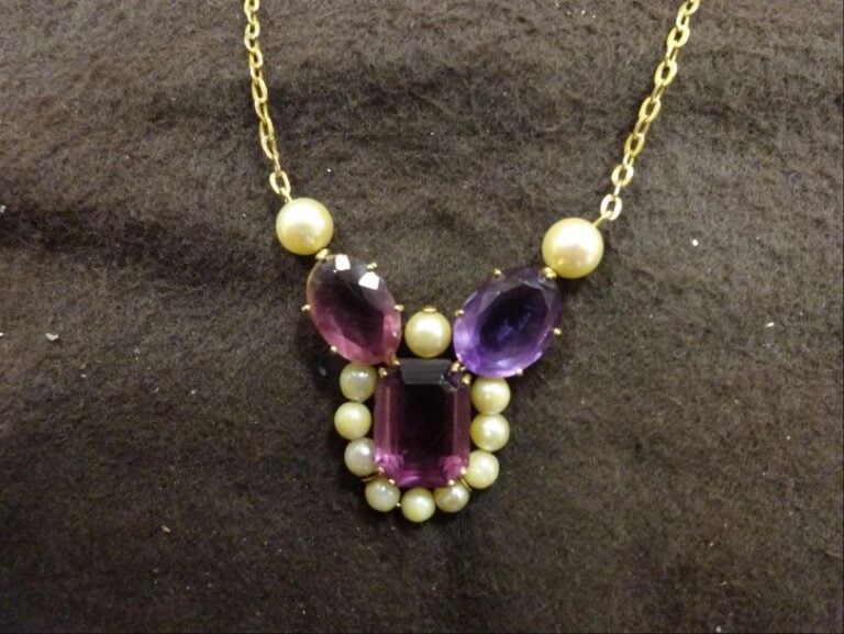 COLLIER en or jaune 18k (750 °/00)  (certains maillons en plaqué or), retenant un motif central serti de deux améthystes et une pierre centrale imitant l'améthyste, entouré de perles de cultur