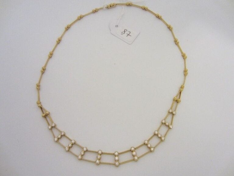 COLLIER en or jaune (750 millièmes) articulé, ajouré, ciselé serti de 31 diamants taille brillan