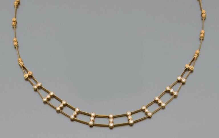 COLLIER en or jaune (750 millièmes) articulé, ajouré, ciselé serti de 31 diamants taille brillan