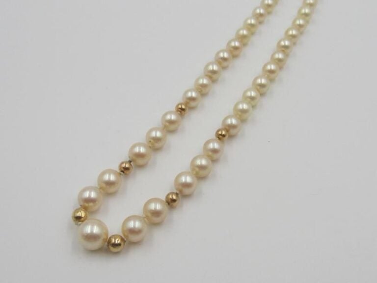 COLLIER en or jaune (750 millièmes) composé d'un rang de perles de cultures blanches en chute, alternées de boules d'o