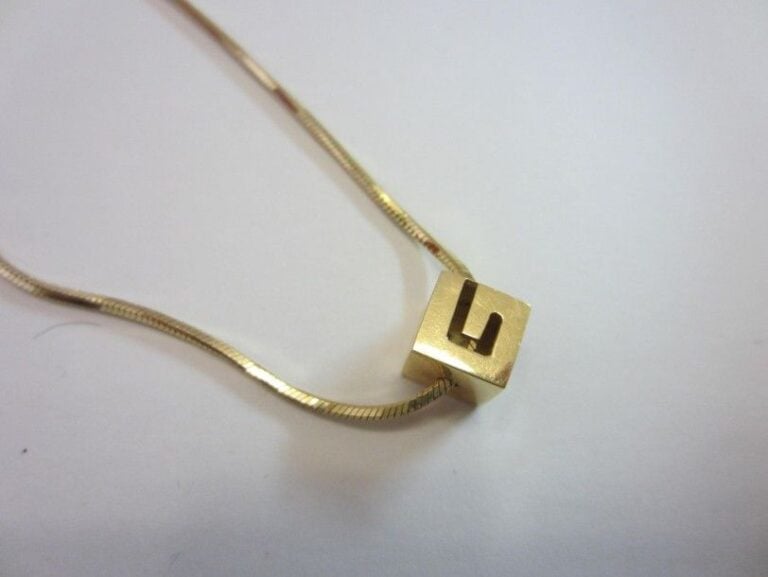 COLLIER en or jaune (750 millièmes) retenant un pendentif «G» de Gucc