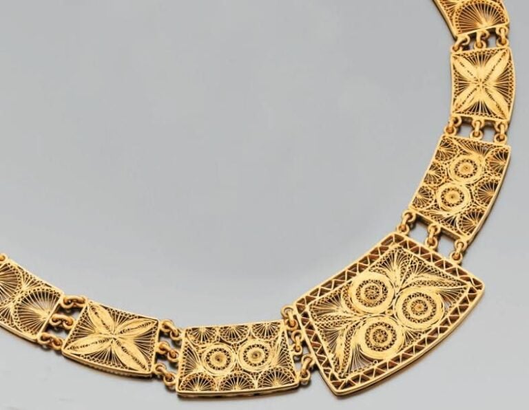 COLLIER en or jaune articulé, filigrané et ajouré à motif de plaques en chut