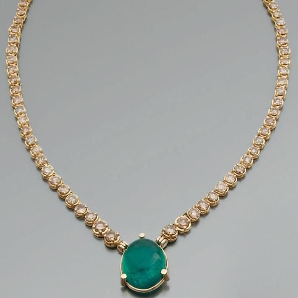 COLLIER en or jaune articulé serti de diamants bruns, en chute retenant une importante émeraude cabocho
