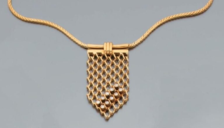 COLLIER en or jaune composé d'une chaîne colonne retenant un motif «cravate» articulé et ajouré en or jaune serti de dix diamants taille brillan