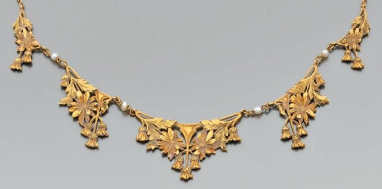 COLLIER en or jaune et or rose, composé d'une fine chainette retenant cinq m otifs de fleurette, en chute, alternés de quatre perles fines baroque