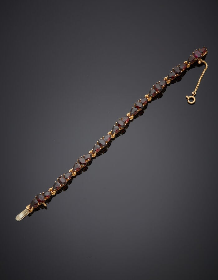 COLLIER et BRACELET en or jaune (750‰) serti de grenats de forme navette, ronde…
