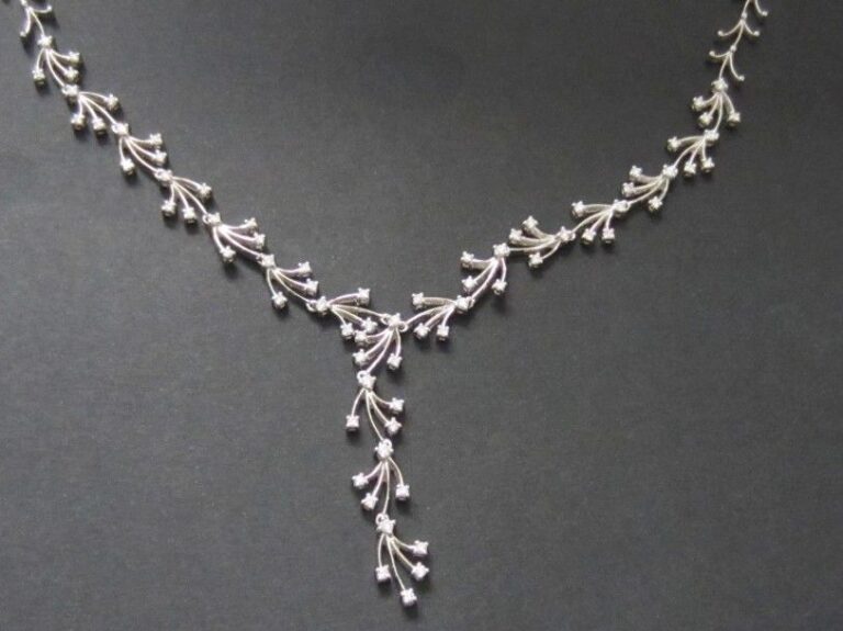 COLLIER « feuilles stylisées » en or gris (750 millièmes) articulé partiellement serti de  diamants taille brillant, dont quatre motifs retenus en pendan