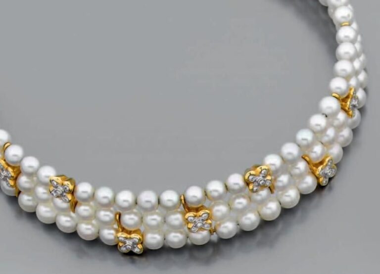 COLLIER flexible ouvert composé de trois rangs de perles de culture blanches alternées de motifs fleurettes en or jaune et or gris serti de diamants taille brillant et retenus et terminés par des barrettes en or jaun