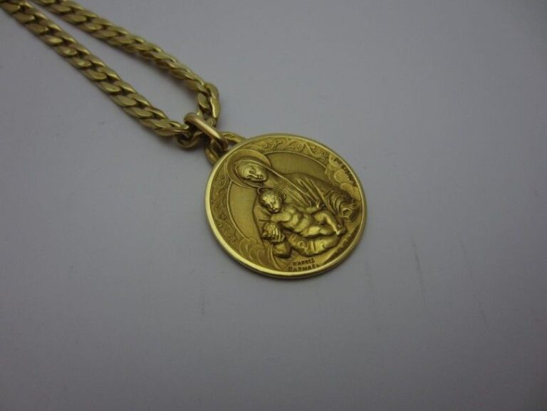 COLLIER «gourmette limée» en or jaune (750 millièmes) retenant une médaille religieus