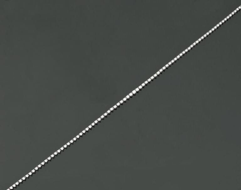COLLIER «rivière» en or gris articulé serti de diamants taille brillant, en chut