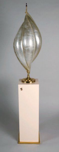 Colonne en plexiglas crème ceinturée d'acier doré en sa base accompagnée de sa lampe formée de pétales de plexiglas enchassés dans une structure de laito