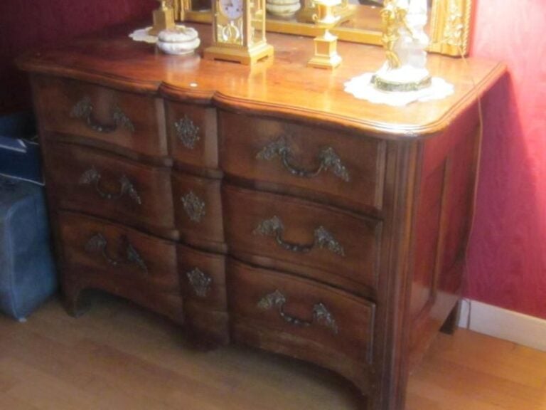 Commode à façade arbalète en bois naturel présentant trois tiroirs en façad