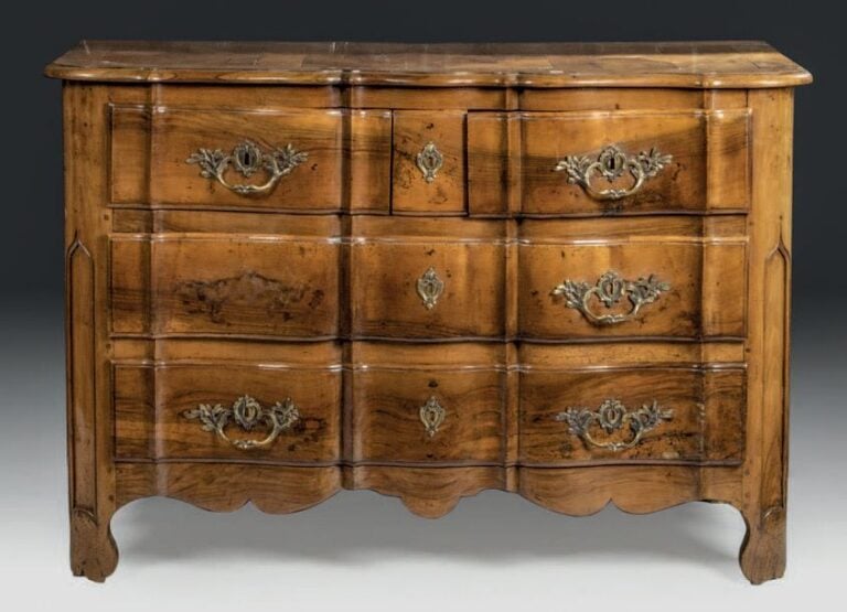 Commode à façade arbalète en noyer sculpté, trois tiroirs en façade; montants arrondi