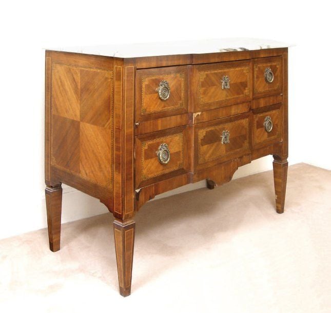 Commode à ressaut, en placage de satiné marqueté dans des encadrements à filet dentelé sur des fonds d'amarant