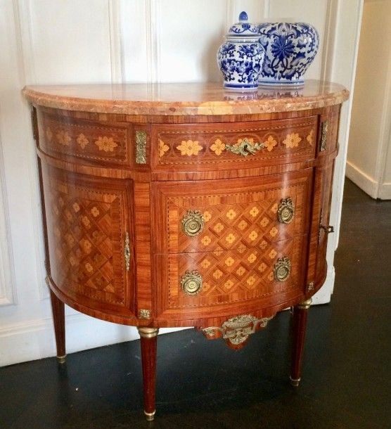 Commode en marqueterie en demi-lune, ouvrant par trois tiroirs et deux vantaux, à décor de fleurons et croisillon