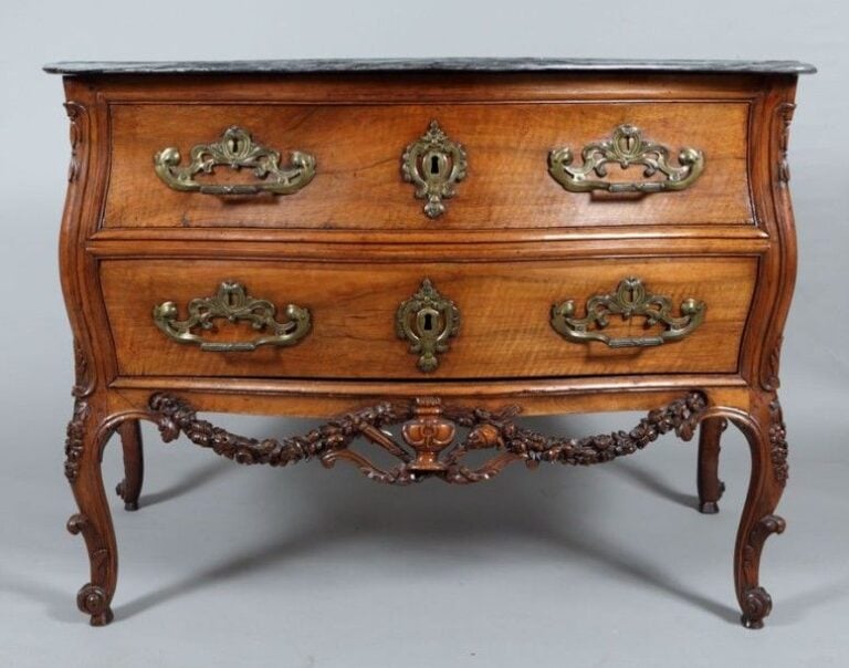 Commode galbée, en noyer richement mouluré et sculpt