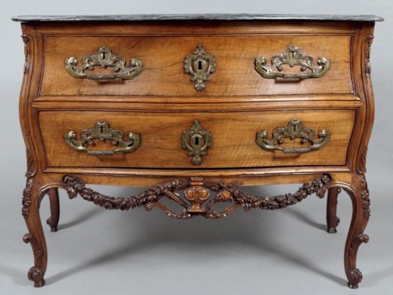 Commode galbée, en noyer richement mouluré et sculpt