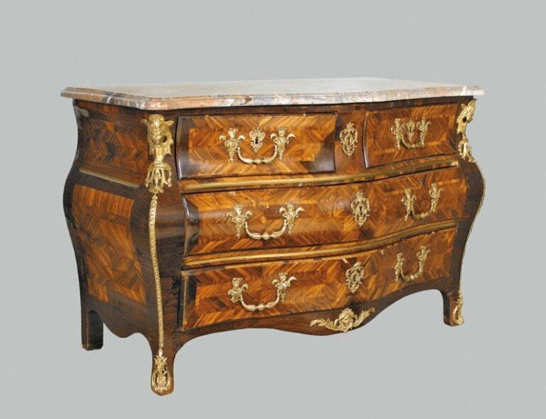 Commode galbée, en placage de bois de rose marqueté en ailes de papillon dans des encadrements d'amarante en file