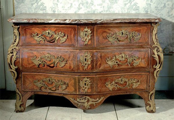 Commode galbée, en placage de bois de rose marqueté en feuilles dans des encadrements à filet de buis sur des fonds d'amarant