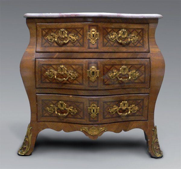 Commode galbée, en placage de palissandre marqueté de croisillons dans des encadrements à file