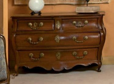 Commode quadrangulaire de forme galbée en acajou et placage d'acajou ouvrant par quatre tiroirs sur trois rangs; petits pieds à enroulement