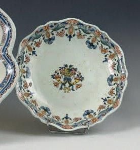Compotier rond à bord contourné, décor polychrome au centre d'un panier fleuri entouré de cornes et sur le bord d'une guirlande à pointillés fleuri