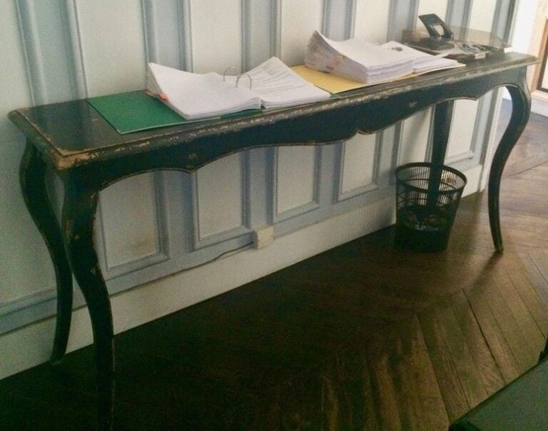 Console en bois laqué noir patinée, ouvrant par deux tiroirs latéraux, style Louis X