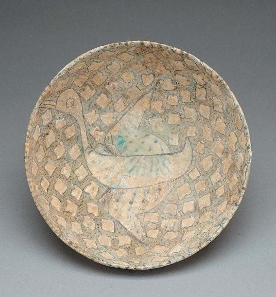COUPE À L'OISEAU Coupe convexe, décorée en léger relief et réserves blanches sur fond gris d'un oiseau en vol parmi des boutons de fleur