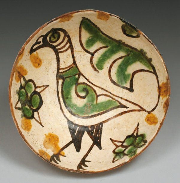 COUPE À L'OISEAU Coupe hémisphérique, décorée en brun et vert sur engobe blanc d'un oiseau dont la queue prend la forme d'un fleuron, entouré de deux fleurs éclose
