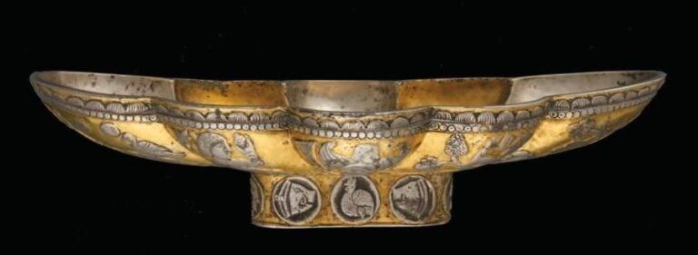 COUPE AU DÉCOR BACCHIQUE Coupe oblongue lobée en argent, dotée d'un petit pied ovale et partagée longitudinalement par deux bandes dont les contours forment huit lobe